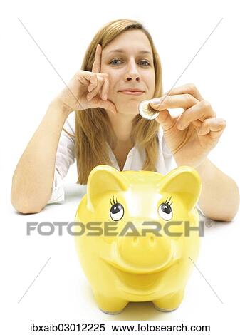 Stock Photography - Woman putting a coin into a piggy bank. Fotosearch