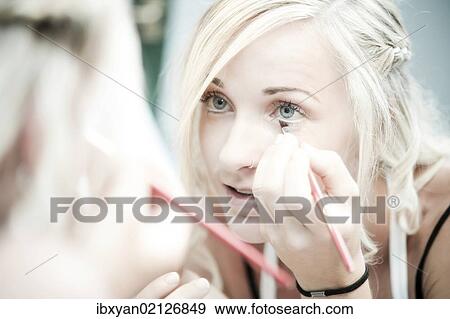 Woman putting on make-up View Large Photo Image Stock Photo - Woman putting on make-up. Fotosearch