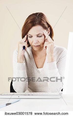 Stock Photo - "Woman sitting at her computer, thoughtful, Mannheim, Baden-Wurttemberg, Germany, Europe". Fotosearch