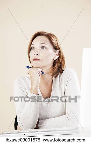 "Woman sitting at her computer, thoughtful, Mannheim, Baden-Wurttemberg, Germany, Europe" View Large Photo Image Stock Photography - "Woman sitting at her computer, thoughtful, Mannheim, Baden-Wurttemberg, Germany, Europe". Fotosearch