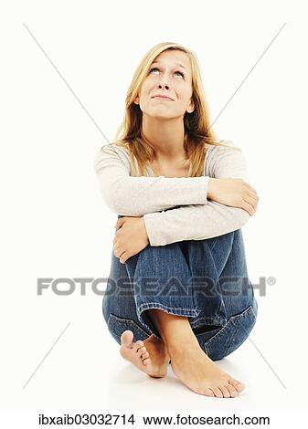 Picture - "Woman sitting with bent knees, dreamy". Fotosearch