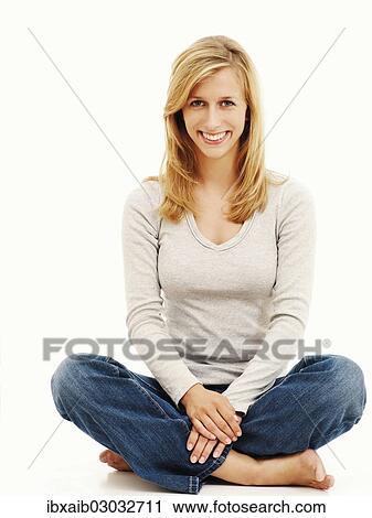 Woman smiling while sitting in a cross-legged position View Large Photo Image Stock Image - Woman smiling while sitting in a cross-legged position. Fotosearch