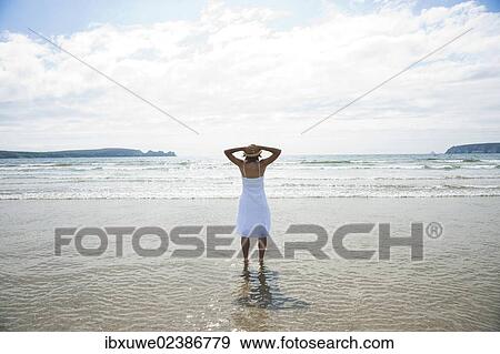 Woman standing on a beach View Large Photo Image Stock Photo - Woman standing on a beach. Fotosearch
