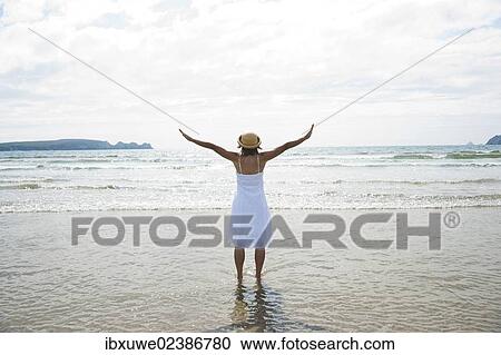 Woman standing with her arms outstretched on a beach View Large Photo Image Stock Image - Woman standing with her arms outstretched on a beach. Fotosearch