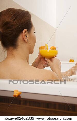 Woman taking a bath and drinking a juice View Large Photo Image Stock Photography - Woman taking a bath and drinking a juice. Fotosearch