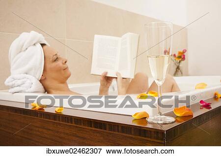 Woman taking a bath and reading a book View Large Photo Image Stock Photo - Woman taking a bath and reading a book. Fotosearch