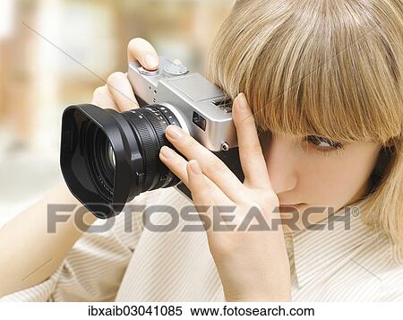 Woman taking a photograph with a camera View Large Photo Image Stock Photography - Woman taking a photograph with a camera. Fotosearch