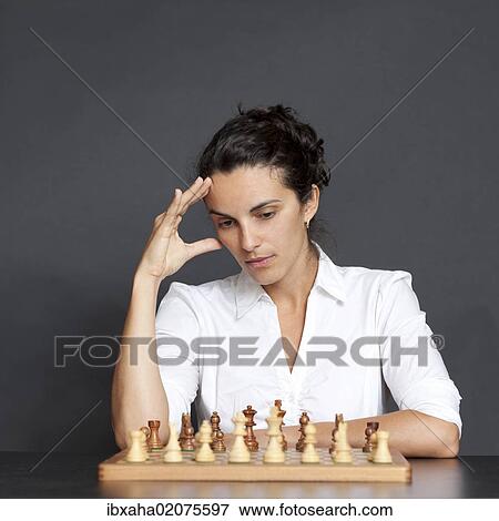 Woman thinking about strategy at a game of chess View Large Photo Image Stock Photo - Woman thinking about strategy at a game of chess. Fotosearch