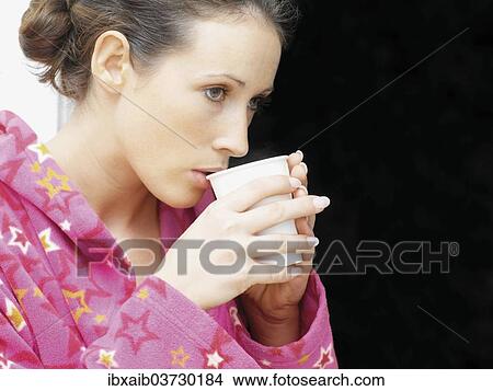 Woman wearing a bathrobe drinking coffee View Large Photo Image Picture - Woman wearing a bathrobe drinking coffee. Fotosearch