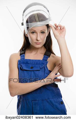 Woman wearing blue overalls and a protective helmet View Large Photo Image Stock Image - Woman wearing blue overalls and a protective helmet. Fotosearch