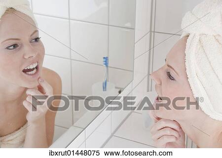 Woman with bath towel and towel on her head in front of the mirror in the bathroom View Large Photo Image Stock Photography - Woman with bath towel and towel on her head in front of the mirror in the bathroom. Fotosearch