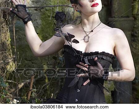 Picture - "Woman with corset holding a black rose, Germany, Europe". Fotosearch