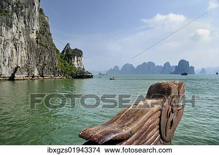 Picture - "Wood carving, dragon head at the bow on a junk, Halong Bay, karst cone in the back, Vietnam, Southeast Asia, Asia". Fotosearch