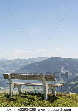 Stock Photograph - "Wooden bench with views of the Alps, Brixen im Thale, Tyrol Austria". Fotosearch