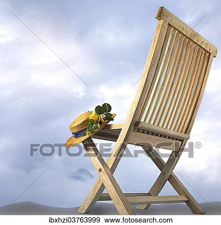Wooden chair with a sun hat View Large Photo Image Stock Photo - Wooden chair with a sun hat. Fotosearch