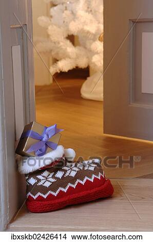 Woolly slipper with Norwegian pattern and present outside an open door View Large Photo Image Picture - Woolly slipper with Norwegian pattern and present outside an open door. Fotosearch