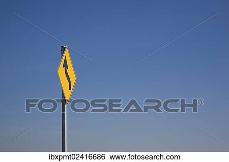 Stock Photograph - "Yellow traffic sign with a curved black """"S"""" arrow against a blue sky, Laval, Quebec, Canada, North America". Fotosearch
