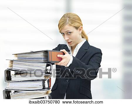 Young business woman piling up folders View Large Photo Image Stock Image - Young business woman piling up folders. Fotosearch