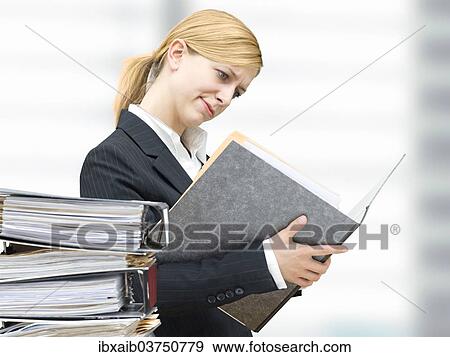 Young business woman reading in a folder View Large Photo Image Stock Photo - Young business woman reading in a folder. Fotosearch