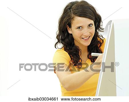 Stock Image - Young businesswoman standing next to a flipchart. Fotosearch