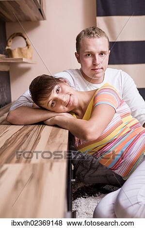 Young couple in a living room View Large Photo Image Stock Photo - Young couple in a living room. Fotosearch