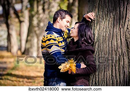 Stock Image - Young couple in a park in autumn. Fotosearch
