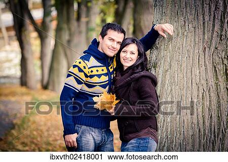 Young couple in a park in autumn View Large Photo Image Stock Image - Young couple in a park in autumn. Fotosearch