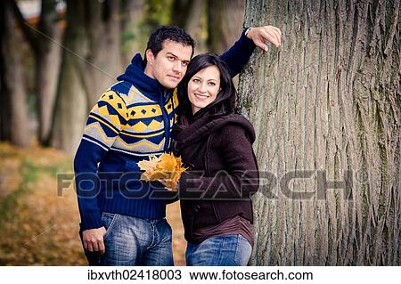 Young couple in a park in autumn View Large Photo Image Stock Image - Young couple in a park in autumn. Fotosearch