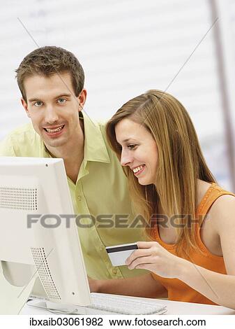 Young couple shopping online with a computer View Large Photo Image Stock Image - Young couple shopping online with a computer. Fotosearch
