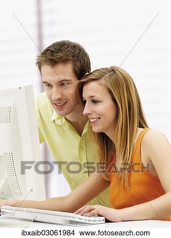 Young couple using a computer View Large Photo Image Picture - Young couple using a computer. Fotosearch
