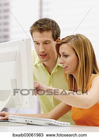 Young couple using a computer View Large Photo Image Stock Image - Young couple using a computer. Fotosearch