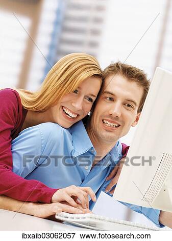 Young couple using a computer View Large Photo Image Stock Photo - Young couple using a computer. Fotosearch