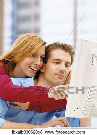 Young couple using a computer View Large Photo Image Stock Photo - Young couple using a computer. Fotosearch