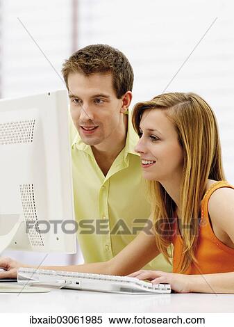 Young couple using a computer View Large Photo Image Stock Photography - Young couple using a computer. Fotosearch