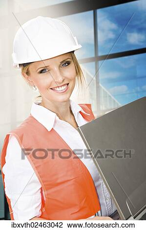 Young female constructor in front of a new building View Large Photo Image Stock Image - Young female constructor in front of a new building. Fotosearch