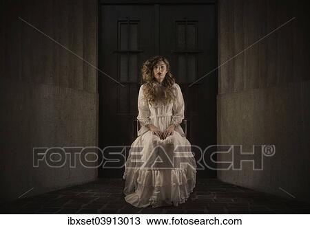 Young girl wearing a white dress sitting in front of a dark door View Large Photo Image Stock Image - Young girl wearing a white dress sitting in front of a dark door. Fotosearch