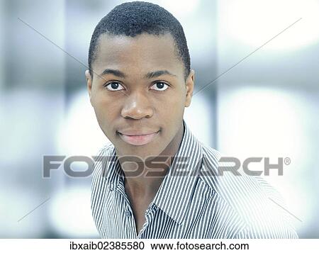 Stock Image - "Young man, African-American, American, serious face, respectable, standing behind glass". Fotosearch