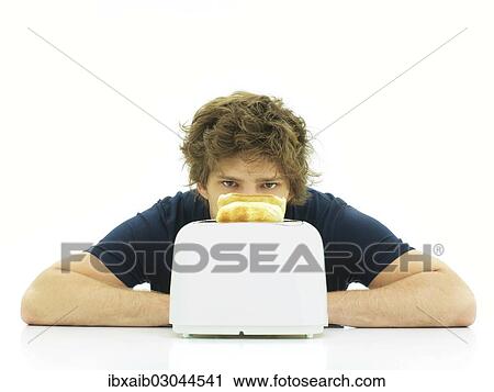Young man behind a toaster with slices of toast View Large Photo Image Stock Image - Young man behind a toaster with slices of toast. Fotosearch