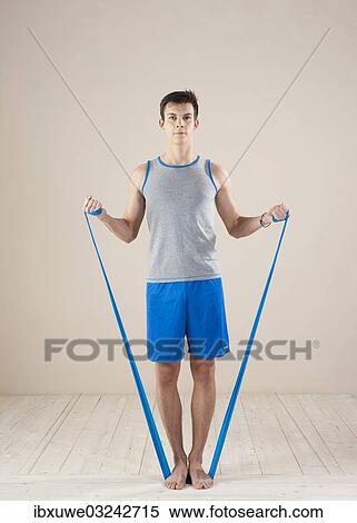 Stock Photography - "Young man doing fitness exercises with a resistance band, Mannheim, Baden-Wurttemberg, Germany, Europe". Fotosearch