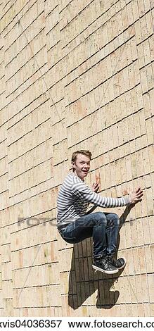 "Young man doing parkour jump on brick wall, Sweden, Europe" View Large Photo Image Stock Photo - "Young man doing parkour jump on brick wall, Sweden, Europe". Fotosearch