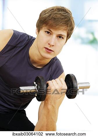 Young man doing strength training with a dumbbell View Large Photo Image Stock Image - Young man doing strength training with a dumbbell. Fotosearch