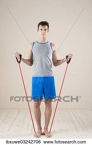 "Young man doing strengthening and stretching exercises with a rubber rope, Mannheim, Baden-Wurttemberg, Germany, Europe" View Large Photo Image Stock Photograph - "Young man doing strengthening and stretching exercises with a rubber rope, Mannheim, Baden-Wurttemberg, Germany, Europe". Fotosearch