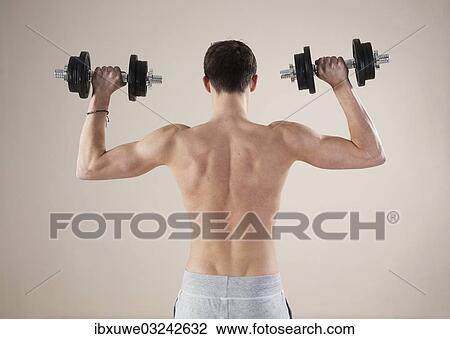"Young man doing weight training with dumbbells, Mannheim, Baden-Wurttemberg, Germany, Europe" View Large Photo Image Stock Image - "Young man doing weight training with dumbbells, Mannheim, Baden-Wurttemberg, Germany, Europe". Fotosearch