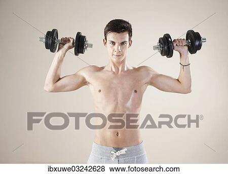"Young man doing weight training with dumbbells, Mannheim, Baden-Wurttemberg, Germany, Europe" View Large Photo Image Stock Photo - "Young man doing weight training with dumbbells, Mannheim, Baden-Wurttemberg, Germany, Europe". Fotosearch