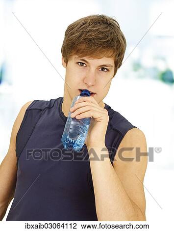 "Young man during training, drinking from a water bottle" View Large Photo Image Stock Image - "Young man during training, drinking from a water bottle". Fotosearch