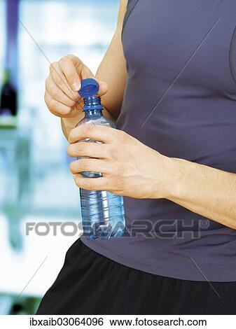 "Young man during training, muscular, opening a water bottle" View Large Photo Image Stock Photograph - "Young man during training, muscular, opening a water bottle". Fotosearch