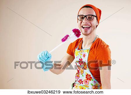 Stock Photo - "Young man holding a toilet brush in his hand while doing the housework, Mannheim, Baden-Wurttemberg, Germany, Europe". Fotosearch