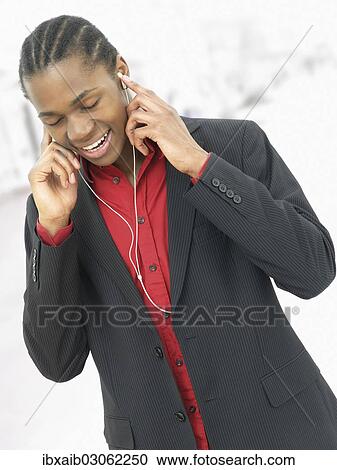 Young man listening to music View Large Photo Image Stock Image - Young man listening to music. Fotosearch