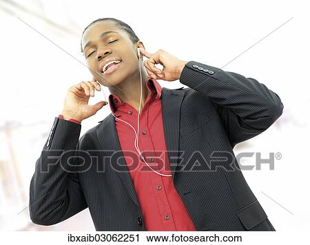 Young man listening to music View Large Photo Image Stock Image - Young man listening to music. Fotosearch