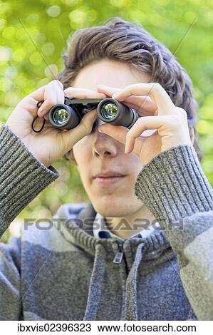 "Young man looking through binoculars, birdwatching, Sweden, Europe" View Large Photo Image Stock Image - "Young man looking through binoculars, birdwatching, Sweden, Europe". Fotosearch